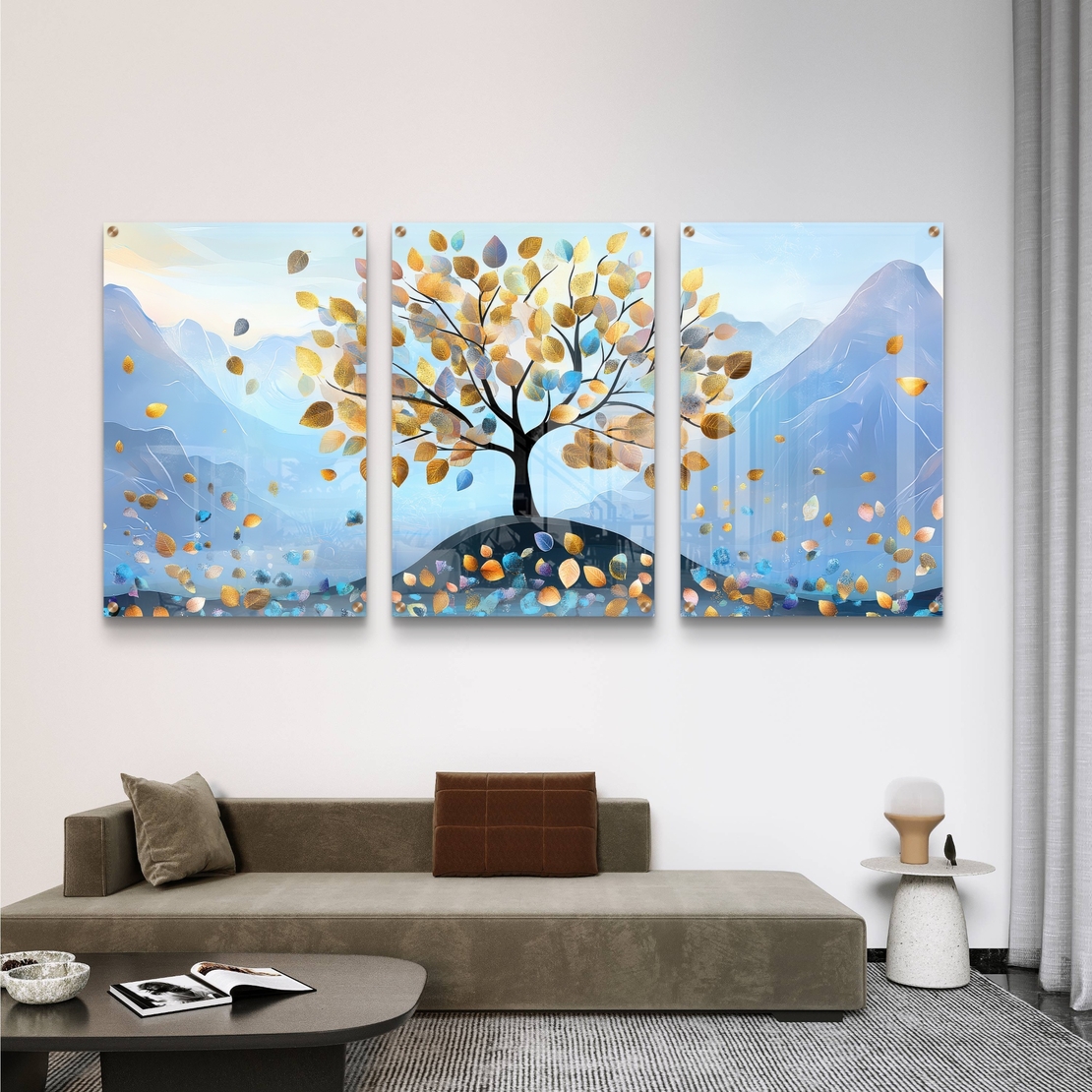 תמונת זכוכית שלישייה עם עץ ועלים בגווני תכלת וזהב על רקע הרים בעיצוב רגוע