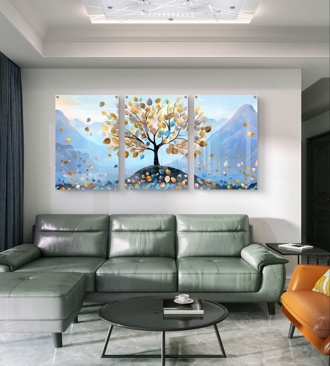 תמונת זכוכית שלישייה עם עץ ועלים בגווני תכלת וזהב על רקע הרים בעיצוב רגוע