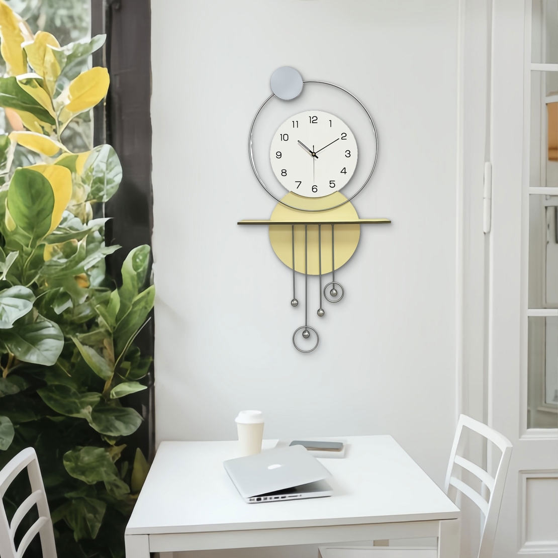 שעון קיר מעוצב בסגנון מודרני עם צורות גיאומטריות, מסגרת עגולה, מטוטלות דקורטיביות וגימור אלגנטי בגווני זהב, אפור ולבן, תלוי על קיר בעיצוב מינימליסטי.